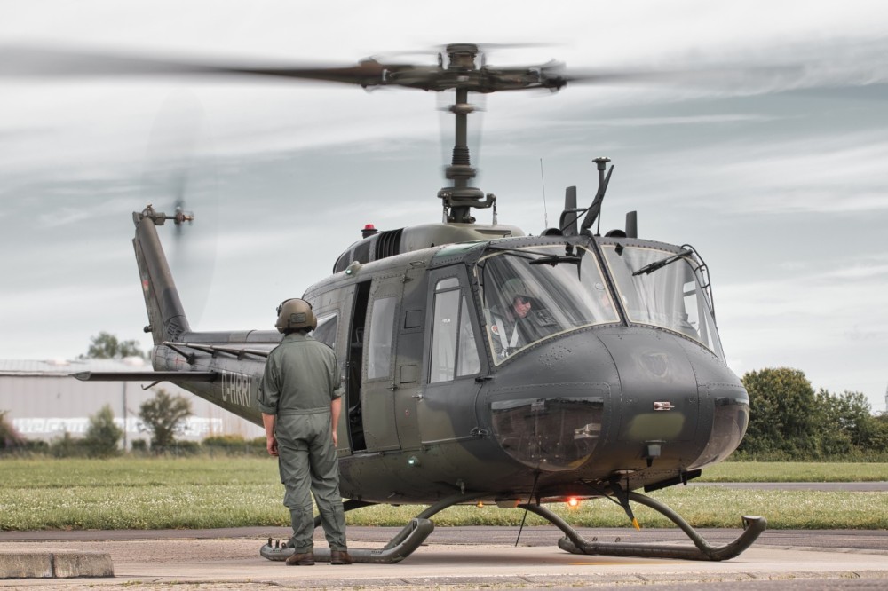 Former German Bell UH-1D after landing. A crew member secures the landing zone and checked that nobody nourishes the helicopter. Shortly afterwards the helicopter was filled. The helicopter is now operated by a private owner.