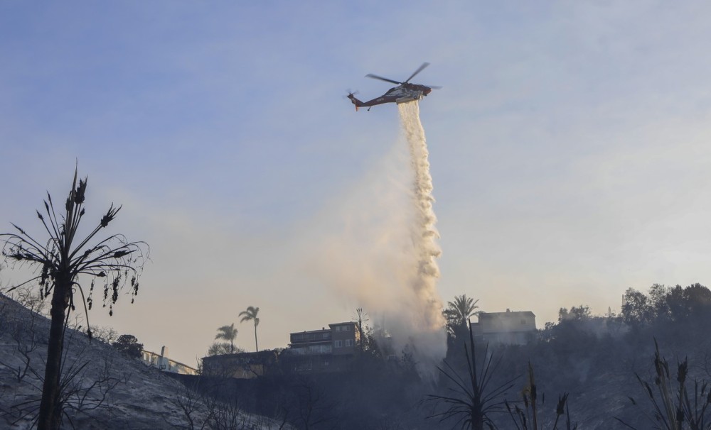 During a raging 37-acre wildfire along Montezuma Rd in San Diego, CA, a Sikorsky S-70i Firehawk (operated by the San Diego Fire Department) douses a hot spot part of the Montezuma Fire.