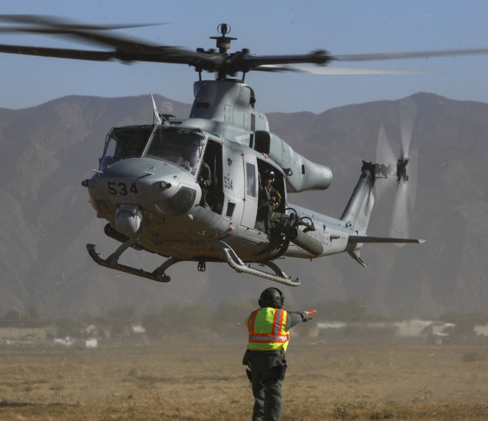 A Riverside County Sheriff deputy from the department's Aviation Unit, directs a Bell UH-1Y Venom to a landing spot during the department's annual fly-in.