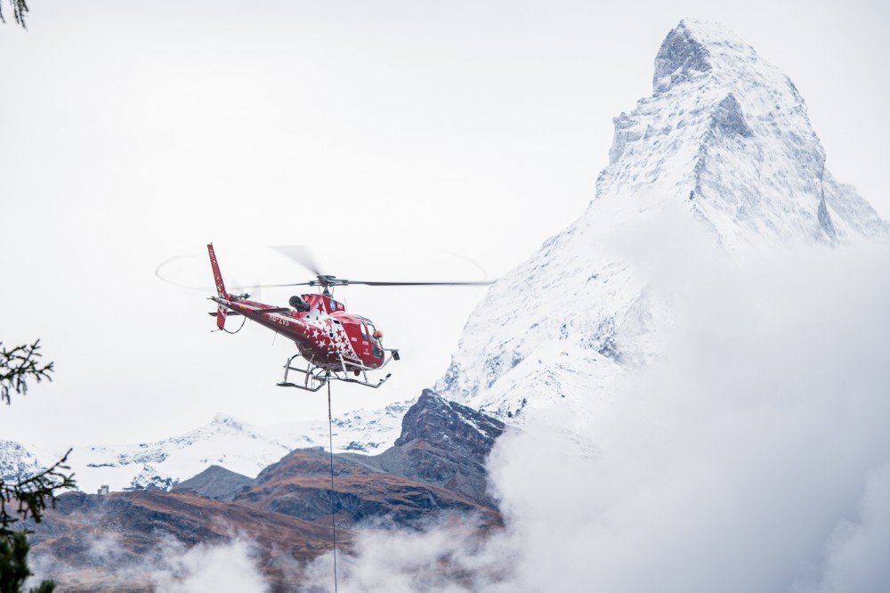 Air Zermatt HB-ZVS - Helicopter External Sling Load (HESLO) in the municipality of Zermatt. 
Helicopter sling load operations in a village require careful planning, skilled crews, and a focus on safety and precision to successfully carry out tasks in an urban setting.