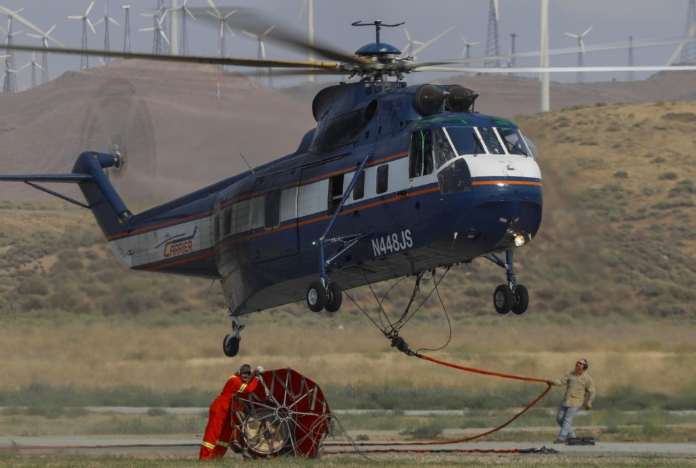 Ground crew of Helitanker 8JS (Sikorsky S-61), assist the pilots during landing on a fuel stop at Mountain Valley Airport in Kern County, CA during the White Fire.