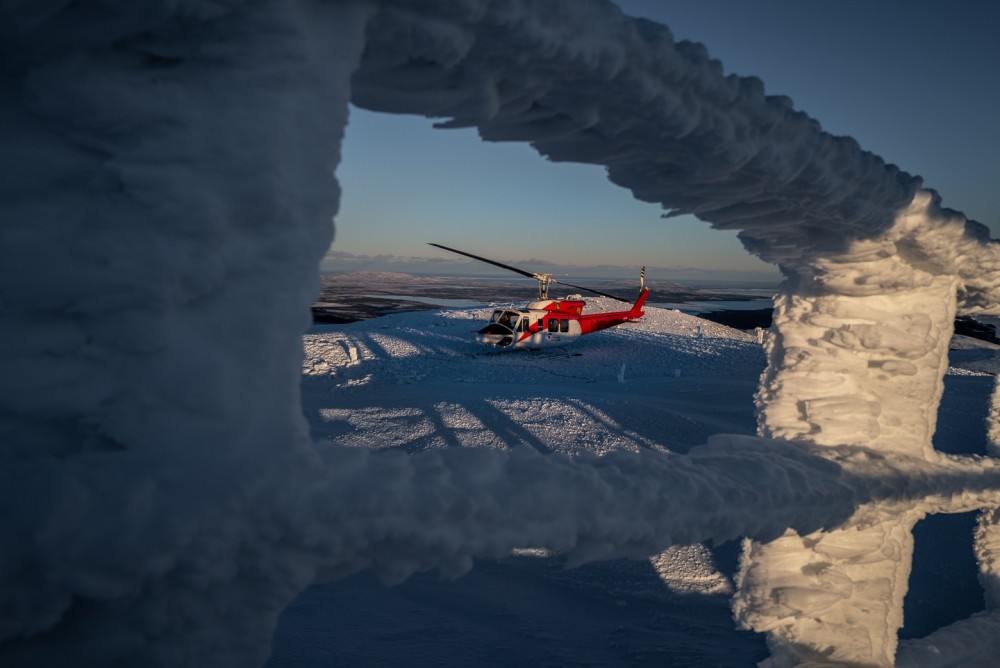 A Bell 212 operated by Canadian Helicopters parked on the helipad at the short range radar site located at Tukialik Bay, Newfoundland and Labrador as the sun sets.