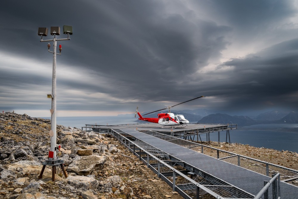 A Bell 212 operated by Canadian Helicopters sits on the elevated helipad at Cape Kakiviak, Newfoundland and Labrador, Canada. The aircraft operates in support of the North Warning System, and this site is a mile south of 60 degrees north latitude.