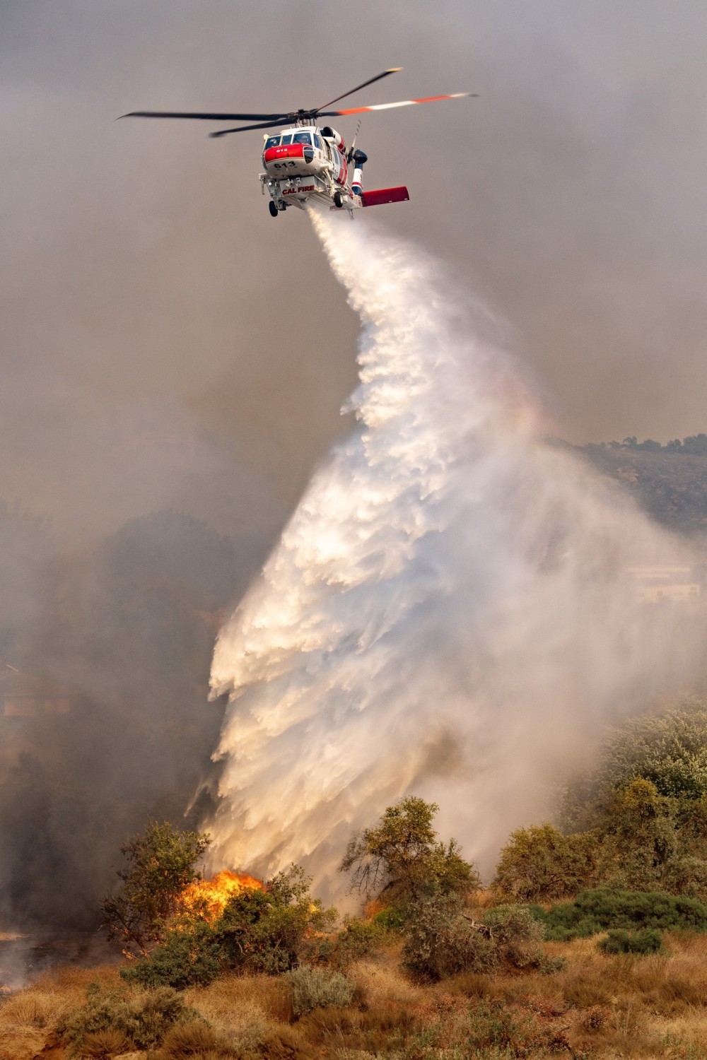 Cal Fire's Firehawk drops water at the Hawarden Fire in Riverside,California. It was really hard getting to the right location to capture the aircraft dropping because it was in a large residential area. I had to navigate around heavy traffic and in a very large area. Unfortunately, the fire destroyed 6 homes and burned about 527 acres.