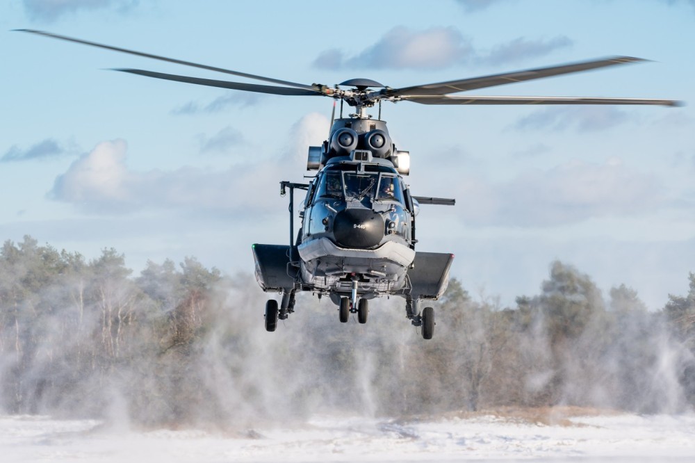 A Eurocopter AS532 Cougar military medium-weight, multipurpose helicopter from the Defense Helicopter Command of the Royal Netherlands Air Force is performing touch and go's manoeuvres in the snow.