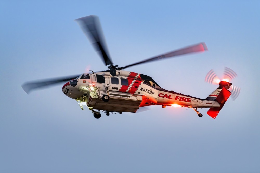 The sun had gone down at the Macy Fire in Lake Elsinore, California as Cal Fires helicopter just finished dropping water. I was walking out of the fire and shot this picture of the Firehawk as it flew over me. I liked how the lights reflected off of the surface of the helicopter.