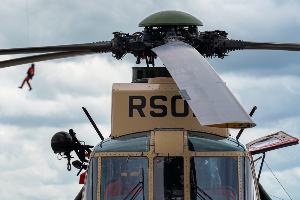 Belgian Air Force mecdic hoisted down form a NH90 helicopter above a Seaking heli