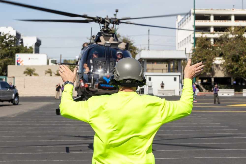 A Bo105 getting directed toward a parking spot at the HeliExpo fly in