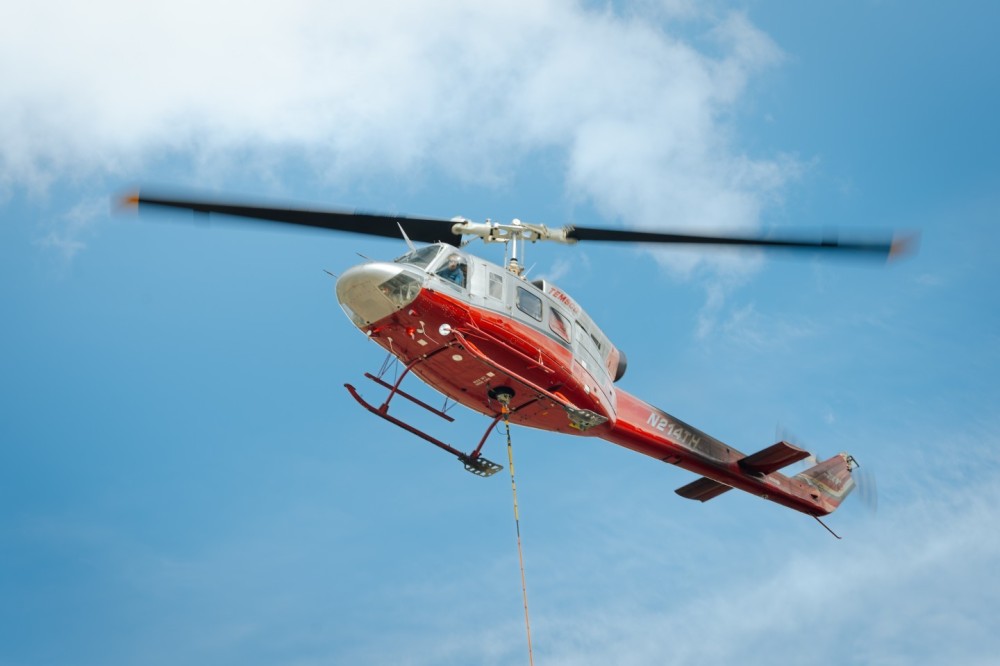 TEMSCO's Bell 214-B1 lifting a snowcat in Skagway, AK. Getting the snowcat up to the glacier is a crucial part of set up for the tour season. The snowcat aids in managing a sled dog camp that is set up on the Denver glacier.