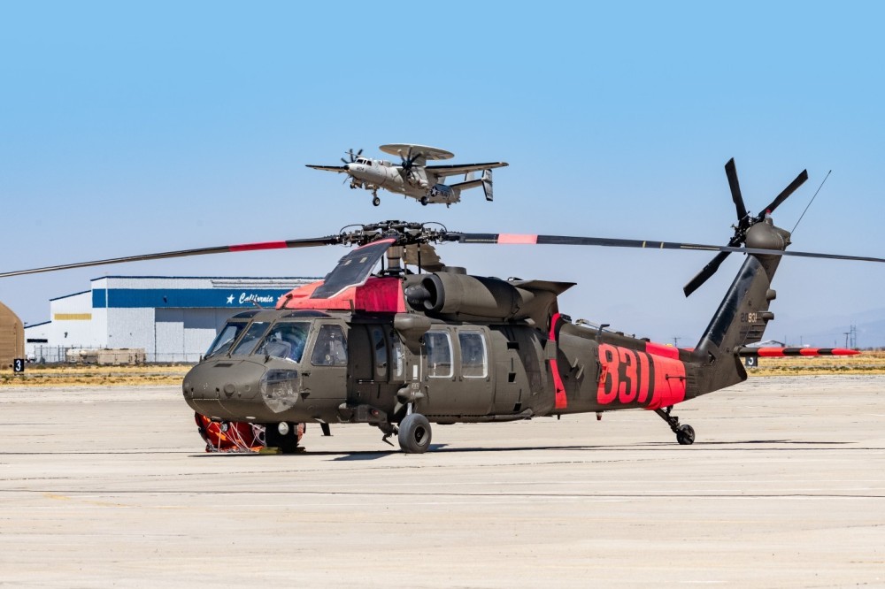 I got permission to go on flight line at Southern California Logistic Airport in Victorville, California. I saw that the Northrop Grumman E-2 Hawkeye was doing touch and goes and I photograph it with the Army Blackhawk in the foreground, which had just come back from fighting the Bridge Fire in the Angeles National Forest.