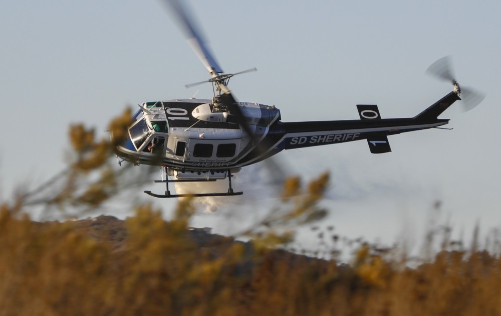 Copter 10 from the San Diego County Sheriff Department's ASTREA Unit, swings around dumping its 350 gallon payload shortly before passing over the Incident Command Post (ICP) during the Millar Fire in Jamul, CA.