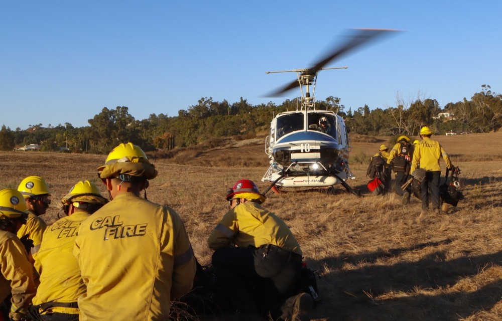 Copter 10 from the San Diego County Sheriff Department's ASTREA Unit, returns to the landing zone to grab the first of two CAL FIRE San Diego Gillespie Helitack crews, at the end of the 50 acre Garden Fire in Fallbrook, CA.