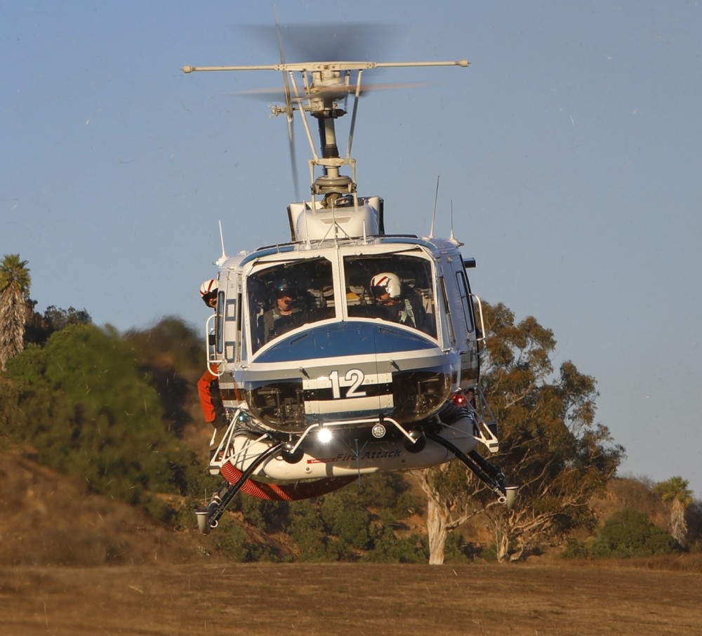 Copter 12 from the San Diego County Sheriff Department's ASTREA Unit, dusts off after picking up the last of the CAL FIRE San Diego Gillespie Helitack crew, headed back to base from the Garden Fire in Fallbrook, CA