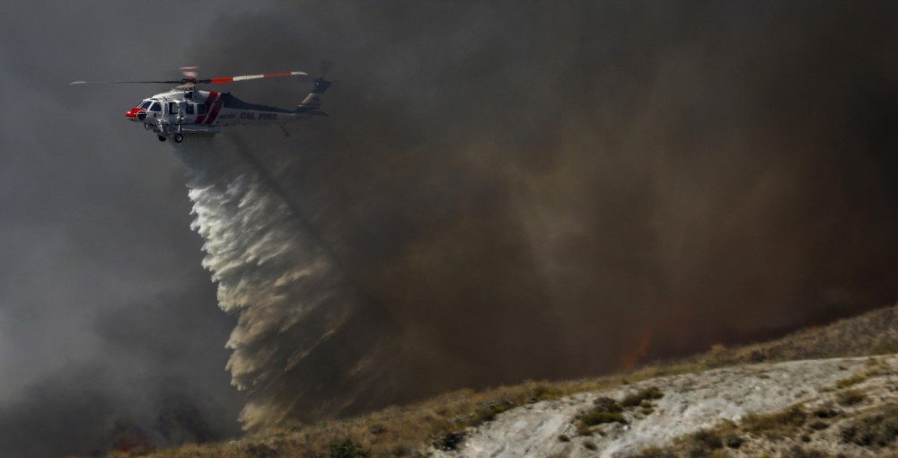 Copter 613 from CAL FIRE's Prado Helitack, responds to a large vegetation rapidly spreading in Moreno Valley of Riverside County (CA). As Copter 613 arrives on scene, its crew is tasked with containing a flank of the blaze.