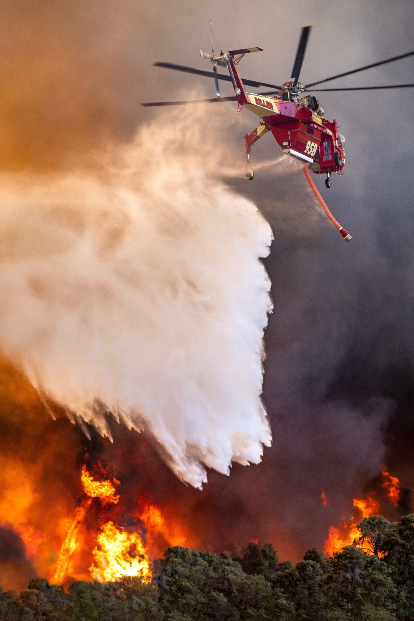 A Siller Helicopter Skycrane drops water at the Sheep Fire near Wrightwood, California. The fire was almost out and what seemed liked minutes, grew to over 1000 races. I drove on  California Highway 2 with intense flames on both sides, following the fire and helicopters.