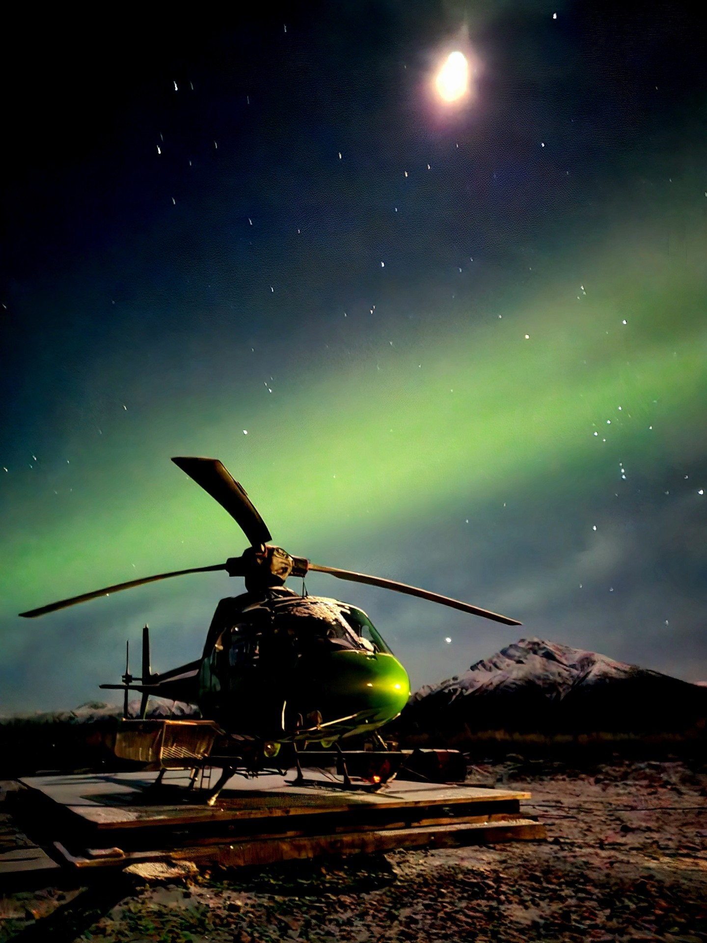 Yukon drill camp central yukon 5.30am with faint Aurora overhead. Horizon Helicopters AS350SD2 about to get preflight inspection before support to 3 fly drills on gold exploration. This morning was the first clear sky after 10 days of early fall overcast cloud and snow conditions -12 deg Celsius