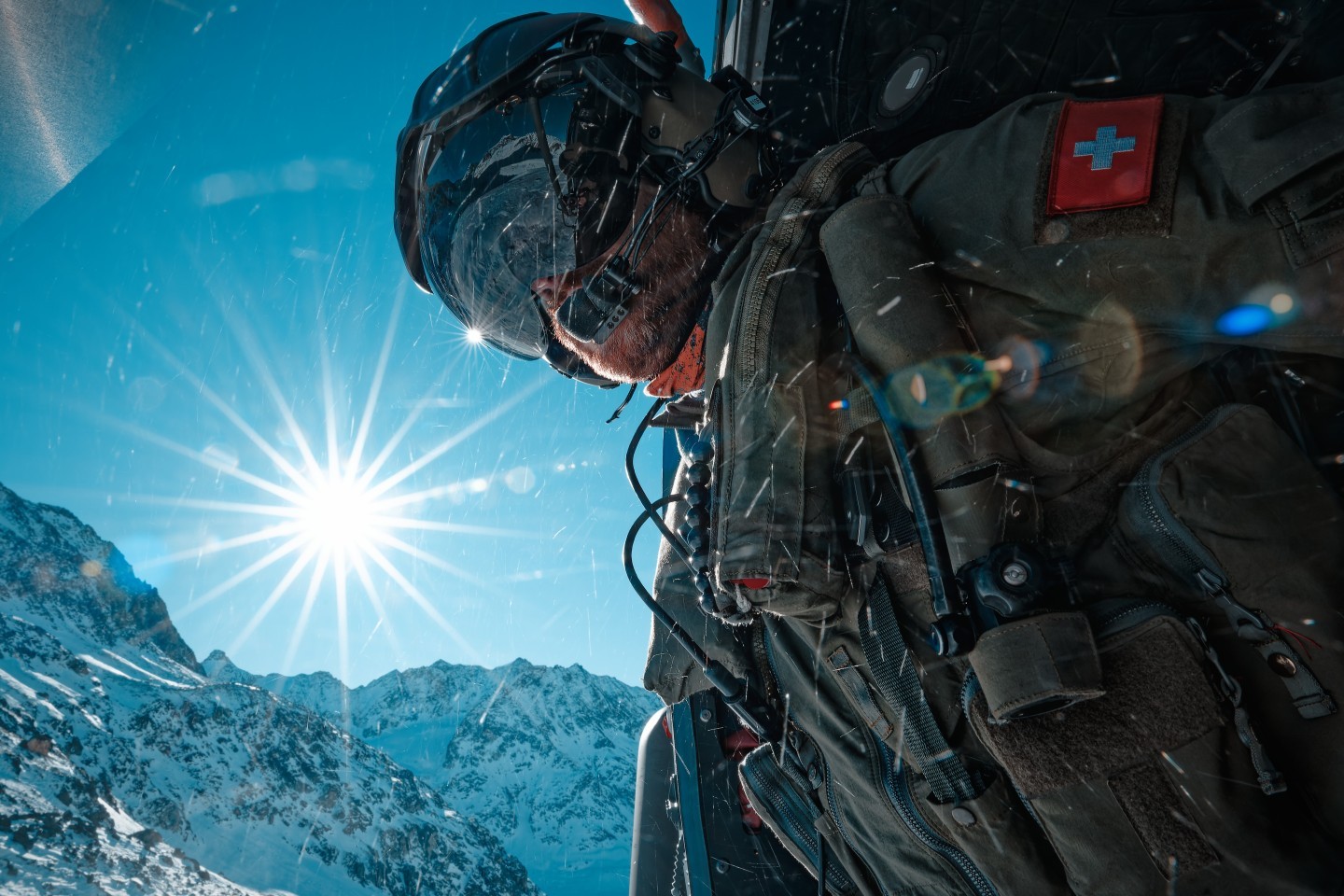 A bord d'un Cougar des Forces Aériennes Suisse, le 3ème homme (Load Master) sécurise le posé sur un glacier. Le glacier se situe au coeur des Alpes Suisse.