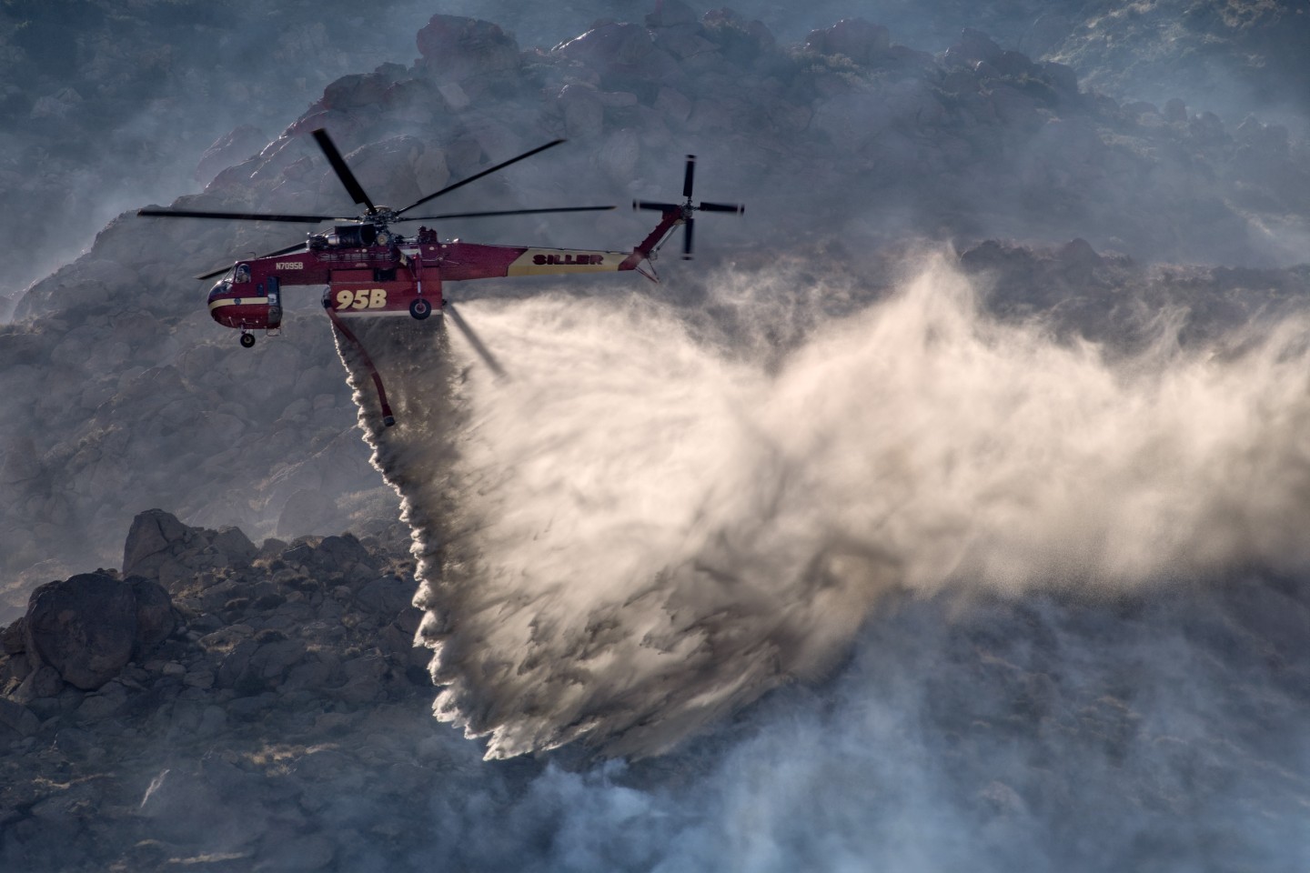 The winds at the Elm Fire near Cabazon, California were extremely strong and it was<br />
really difficult to hold my camera still, especially with my Nikon 200mm to 500mm f/5.6 lens. In<br />
addition, the mountainous terrain made it more challenging to photograph. However, finding the<br />
right position produced some really dynamic photographs, especially this one taken close up to highlight the helicopter's abilities. Watching Siller’s Skycrane, with their amazing pilots,<br />
maneuver in the adverse weather and mountainous area, was amazing to document.