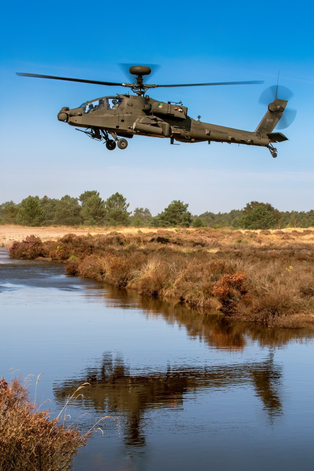 An AH-64E Apache hovers over a flooded area at a Dutch Army Training Area. The Netherlands is upgrading its legacy AH-64D fleet to the ‘Echo’ (E) Version 6 standard and operates a fleet of 28 airframes