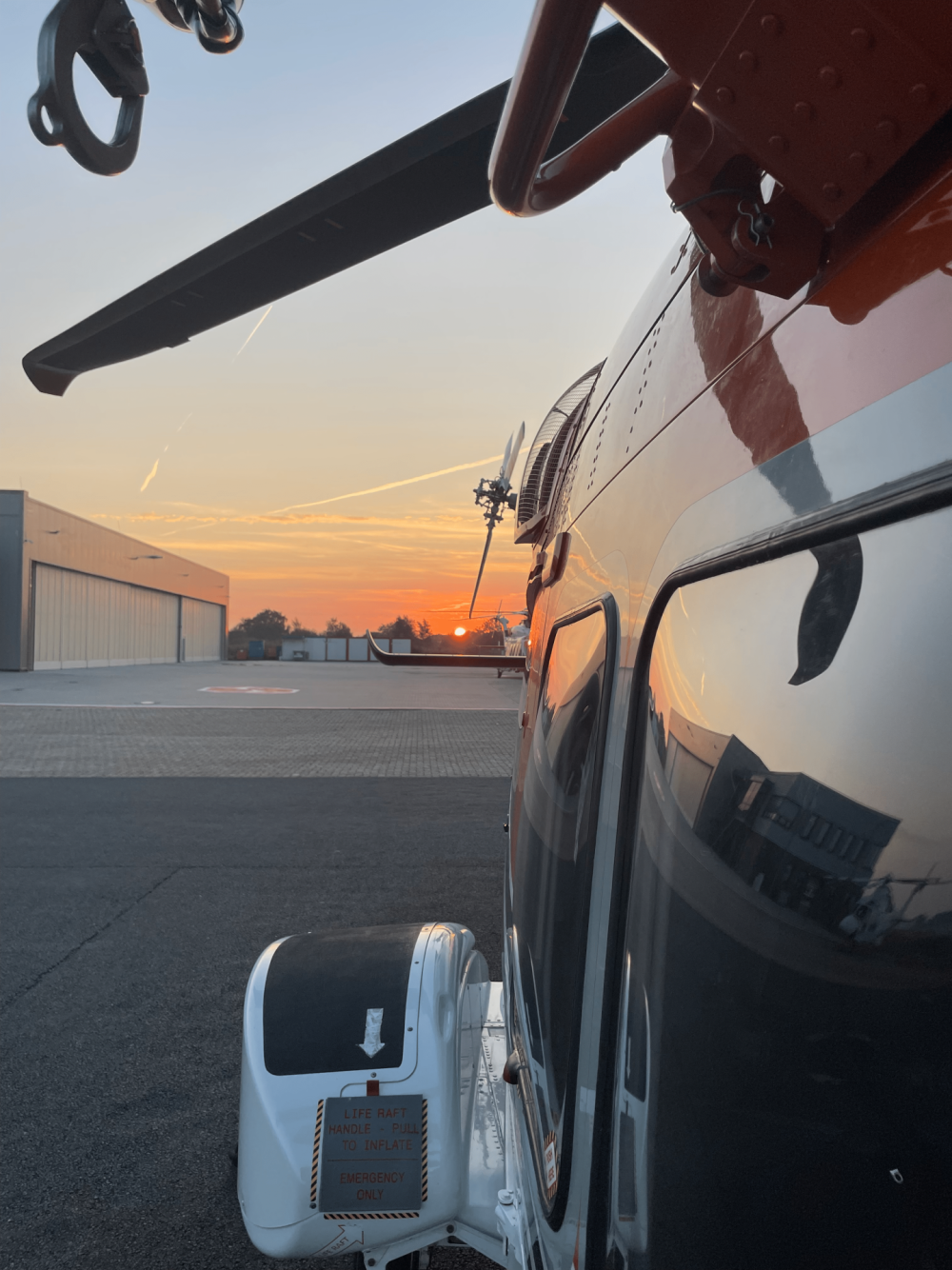 Getting ready for Hoist mission. Crew was checking the helicopter. Did their walkaround as usual to check everything. When one of the crew spotted the sunrise he decided to take this beautiful picture and took off for a hoist mission in a wind farm in the North Sea.