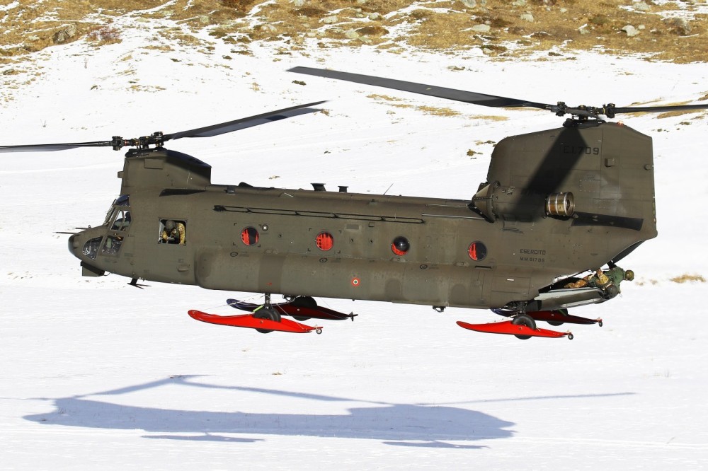 An Italian CH-47F (EI-709 MM81786) of Aviazione dell’Esercito landing on a snowy plateau during “Volpe Bianca” exercise; the helicopter is equipped with snow landing skids