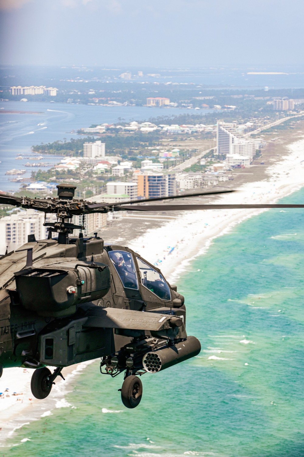 An American AH-64E Apache helicopter out of Fort Novosel, Alabama flies down the Gulf Coast over the Atlantic Ocean. The AH-64 is the primary attack helicopter of the United States Army.