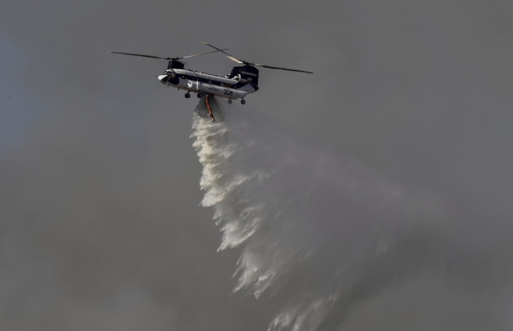 PJ Helicopters Helitanker 2CH, a heavily modified Boeing CH-47D Chinook, making it rain on a 344 acre vegetation fire dubbed the "Round Fire" in Moreno Valley, CA.