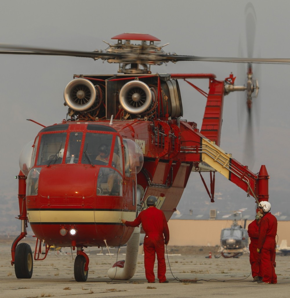 Siller Helicopters Helitanker 25M and its pit crew, assist the pilots with a successful startup prior to lifting off while assigned to the raging Line Fire in Highlands, CA.