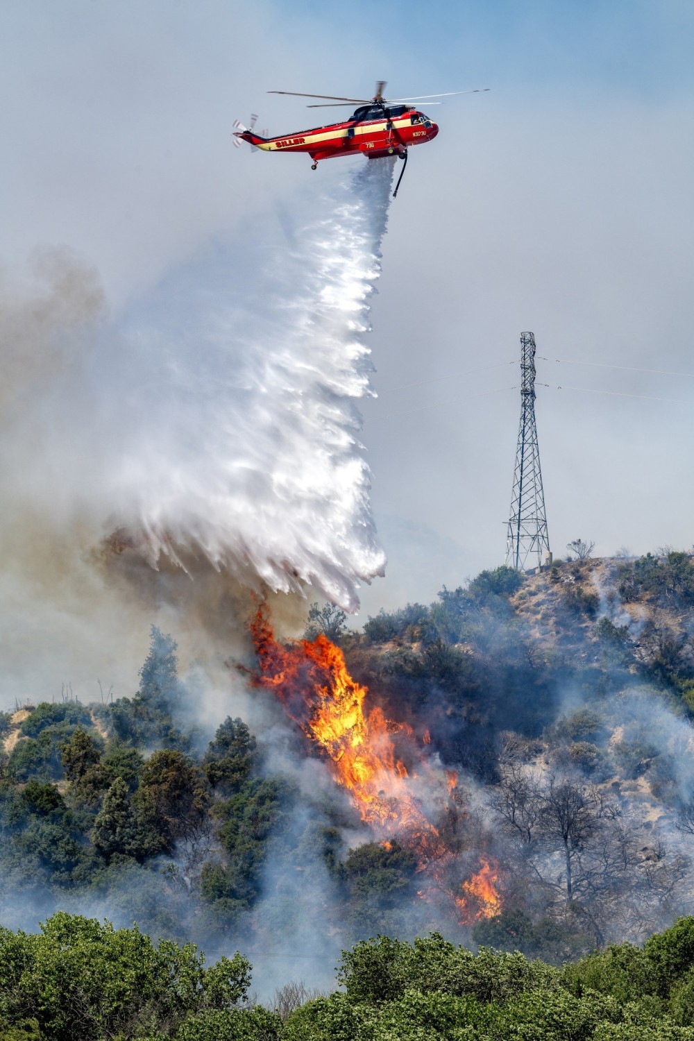 I started heading to the Post Fire near Gorman, California on the first day.  Because of heavy traffic, it took me over 4 hours to get there.  I decided to stay overnight so I could go back to the fire. I saw where the helicopters were dropping and pulled on to a dirt road to get in the right position. All of a sudden the brush flared up, at the exact time Siller’s Sikorsky SR-61A was getting ready to drop. I shot many others helicopters there, but none with the intense flame. Getting to the right location takes a lot planning, luck, and timing.