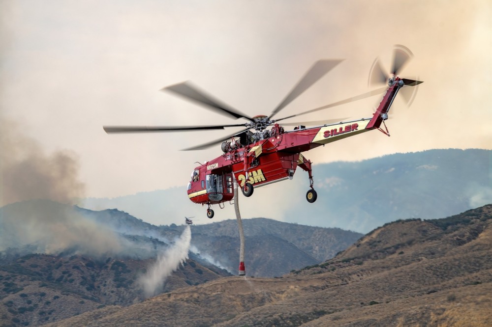 I found the reservoir in Highland, California where the helicopters were refilling to drop at the Little Fire, after driving on a few dirt roads.  After the Siller Skycrane was heading back to drop on the fire, I took this picture with Helimax’s Chinook dropping water in the background. The sun was diffused by a smoke-filled sky.