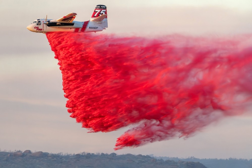 The most difficult thing with this photograph was trying to get to the location where Cal Fire’s S-2 was dropping retardant, and before the sunset. My son did the navigation as we drove down multiple, rough dirt roads. When we got to the right location, we had to climb a small hill so that we had a clear very and waited for, hopefully, another Phos-Chek drop. We got this photograph within seconds before the sun was obscured by a mountain. There was only a very small opening to get a clear view because of all the trees and brush.