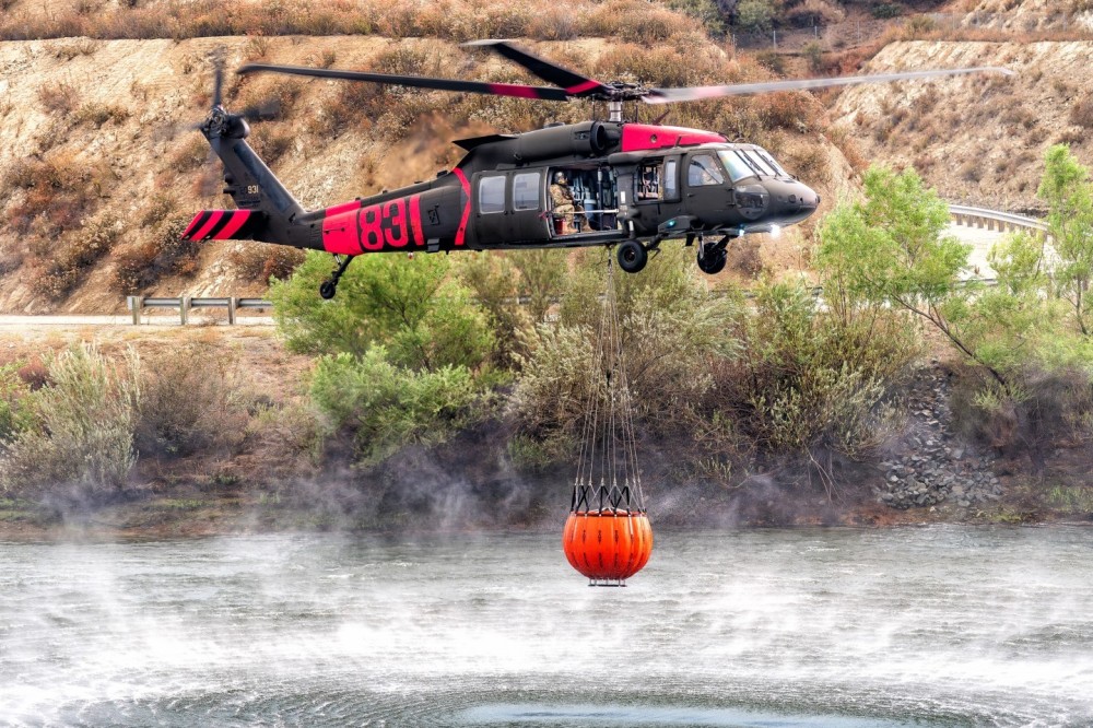 A Los Alamitos National Guard Blackhawk helicopter picks up water from the Crafton Hills Reservoir in Yucaipa, California to dump on the Line Fire. I positioned myself on a hill above the reservoir for the best angle and to clear the fence that was around it.