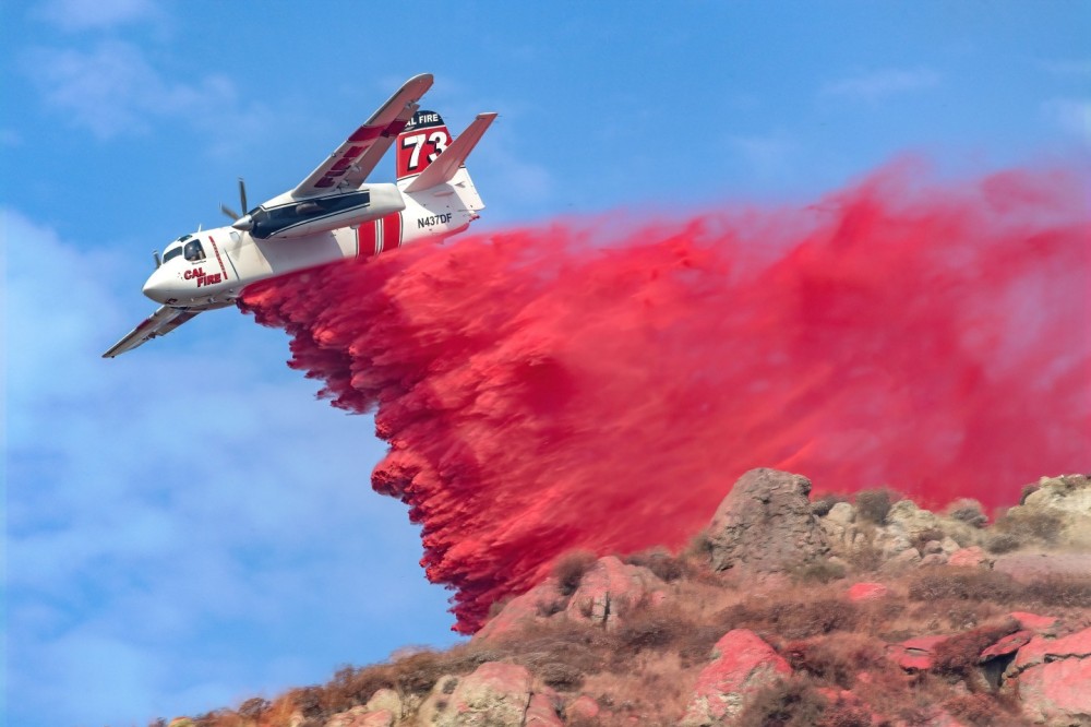 Cal Fire’s S-2 dives down on a steep hill to drop retardant on the Columbia Fire in Moreno Valley, California. In order to get the best angle, I was able to go on private property. The owner of the property was involved with  developing  firefighting chemicals and his house had a metal rood with all vegetation removed from around the perimeter.