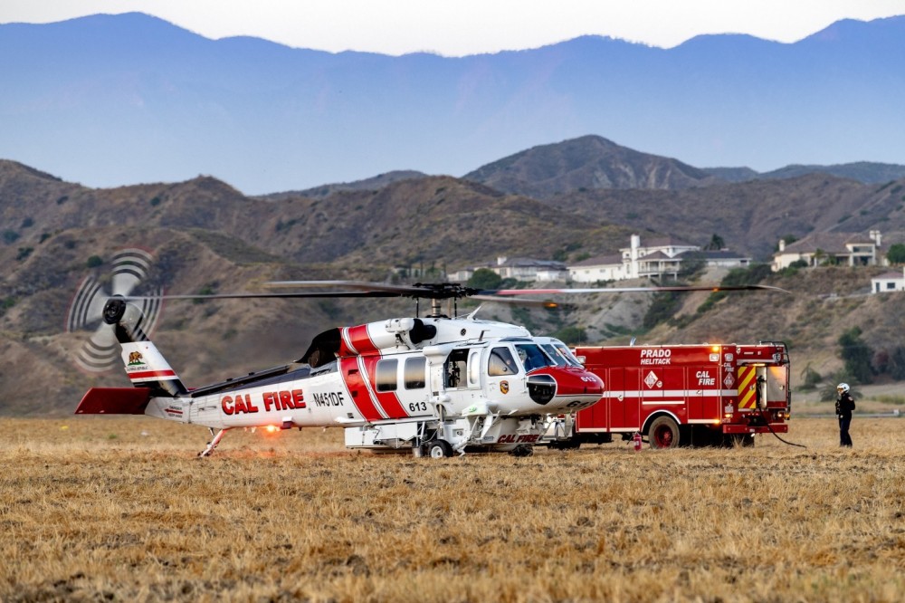 Prado Helitack’s Firehawk gets fuel at the Lisa Fire in Moreno Valley, California as a crew looks on. The sun had just set and it produced a nice soft light.