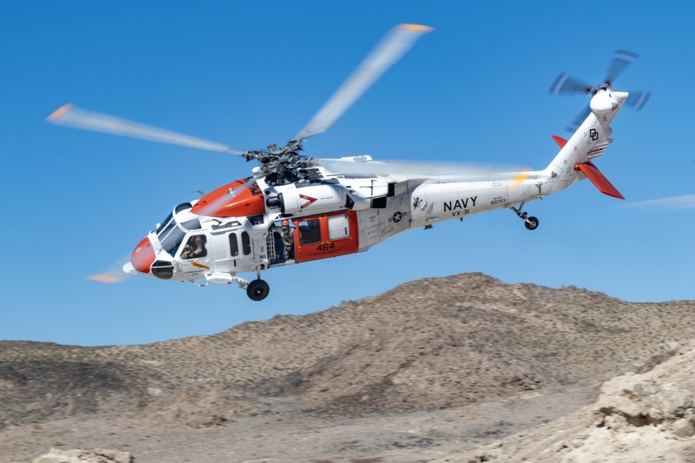 Naval Air Weapons Station China Lake Search and Rescue MH-60S Blackhawk practices out in the Southern California desert. A crew member looks out as the Blackhawk does a low and fast turn.