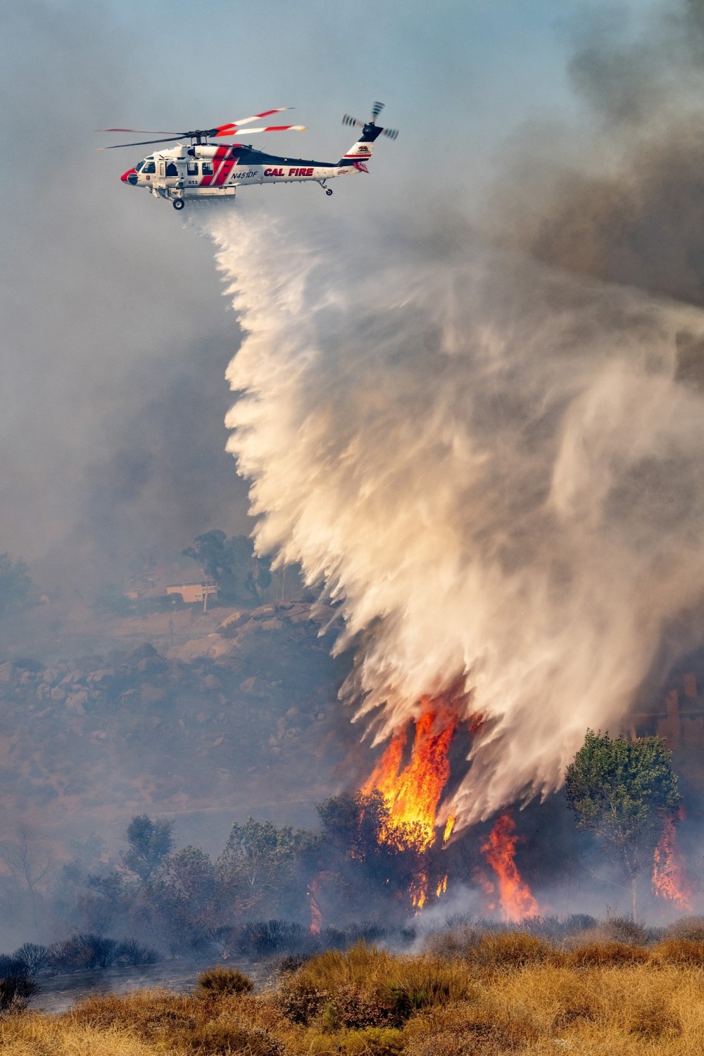 Cal Fire's Firehawk drops water at the Hawarden Fire in Riverside,California. It was really hard getting to the right location to capture the aircraft dropping because it was in a large residential area. I had to navigate around heavy traffic and in a very large area. Unfortunately, the fire destroyed 6 homes and burned about 527 acres.