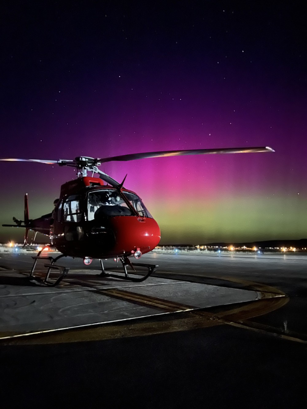 Reach airmedical helicopter at Owyhee tribal airport, awaiting a patient pickup from a vehicle accident. Northern lights background when they extended farther South than normally visible.